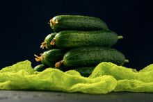 A Bunch Of Green Ripe Cucumber Fruits On The Dark Background. Vegetable Pyramid Composition On Table.