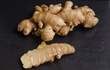 Fresh organic ginger on black stone background