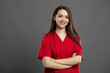 © Catalin Pop - Portrait of a confident young nurse with braces wearing red scrubs