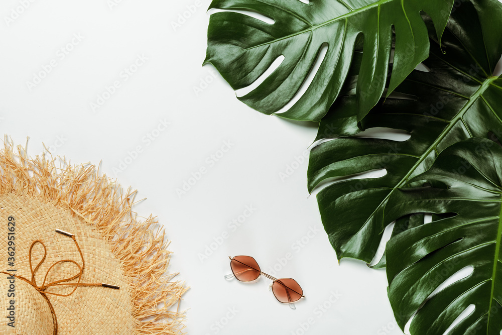 top view of green palm leaves, straw hat and sunglasses on white background - obrazy, fototapety, plakaty 