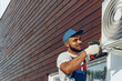 © fotofabrika - Repairman in uniform installing the outside unit of air conditioner