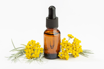 Wall Mural - Helichrysum essential oil on amber bottle isolated on white background. Herbal oil