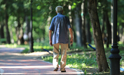 old man walking in summer park