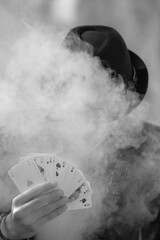 Sticker - Grayscale portrait of a mystical male gamer's hand holding poker cards with smoke in the foreground