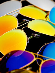 Poster - Sunglasses with colorful lenses on black background