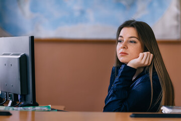 Portrait of young female student looking at computer. Tired slee