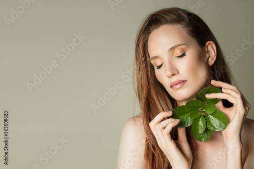 Cuadros en Lienzo A beautiful woman holds a green leaves in her hands