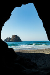 Wall Mural - Vertical Image - Cave exit frames view of Sea Stacks on beach in Oregon
