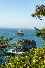 Wall Mural - Vertical Image - Green trees frame view of Sea Stacks along coast near Cape Meares in Oregon