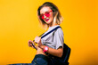 Fashion image of young happy woman wearing casual sportive outfit, backpack and neon glasses, healthy lifestyle concept.