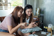 © waranyu - two women use phone together, girl typing smartphone, online shopping