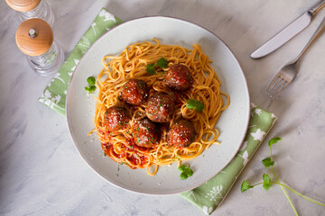 Wall Mural - Meatballs and pasta with tomato sauce on plate. Overhead horizontal image