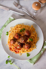 Wall Mural - Meatballs and pasta with tomato sauce on plate. Overhead vertical image