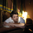 © ImageHit - Man lying on the couch reading book
