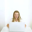 © ImageHit - Girl laughing while using laptop