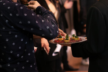 People mingle with canapes