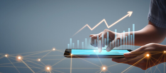 Graph growth and increase of chart positive indicators in his business, tablet in hand