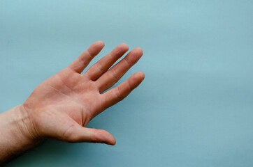 Open palm of the right male hand on blue background.