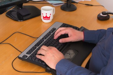 Wall Mural - High angle view of a person using a computer on a desk under the lights