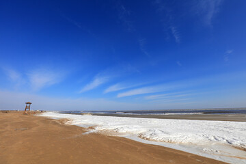 Canvas Print - Watchtower on the sea, snow in the blue sky