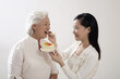 © ImageHit - Woman feeding senior woman a slice of cake