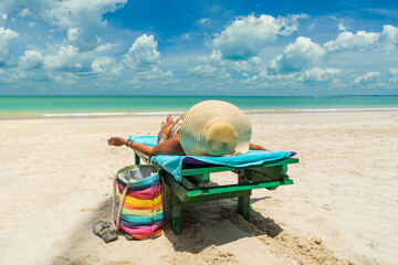 Wall Mural - Woman on a sun lounger at the white sand tropical beach