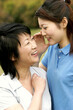 © ImageHit - A lady whispering a joke into her mother's ear