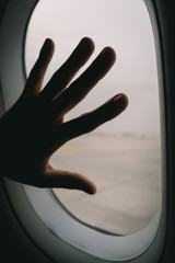 hand on an aeroplane window