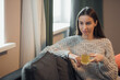 © VERSUSstudio - Woman wearing a sweater holding a cup of tea