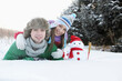 © ImageHit - Man and woman posing with snowman
