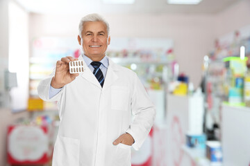 Canvas Print - Professional senior pharmacist with pills in modern drugstore