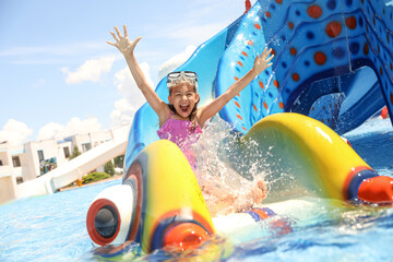 Wall Mural - Little girl on slide at water park. Summer vacation