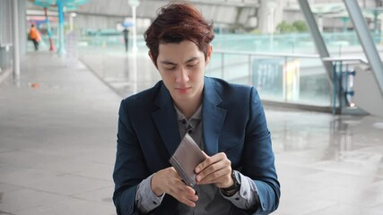 Worried Asian Businessman checking Empty Wallet, Poverty or bankruptcy concept, Asian Businessman having no money in pocket and unemployed.