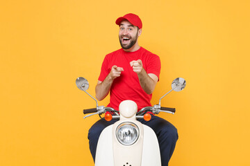 Wall Mural - Delivery man in red cap t-shirt uniform driving moped motorbike scooter isolated on yellow background studio Guy employee working courier Service quarantine pandemic coronavirus virus covid-19 concept