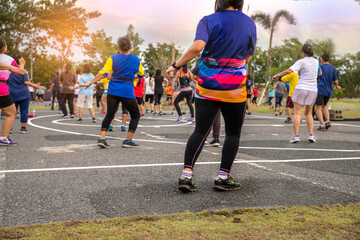 Group of people, woman  exercising with aerobics dancing in the garden.