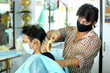 © MukeshKumar - An Indian male hair dresser cutting hair in his beauty saloon with proper safety measures for Covid-19.Cutting hair of a man in mask. Hair care during Covid-19.Beauty saloon opens after lock down.