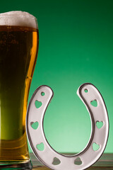 Wall Mural - St Patrick's Day beer and lucky horseshoe against a green background