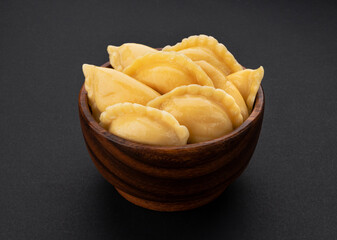 Wall Mural - Dumplings, russian vareniki, pelmeni on black background