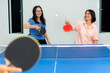© yongkiet - Asian family fun playing table tennis or Ping pong indoor together leisure with competing in sports games in the house. Mother and daughter enjoy recreation or exercise stay at home in Thailand
