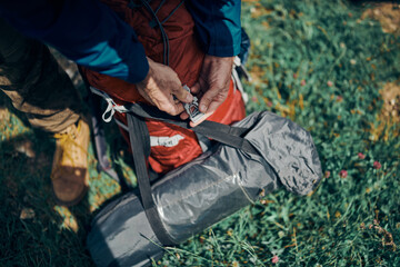 Closeup of man buckling up his backpack.