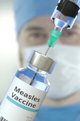 Wall Mural - Medical bottle with measles vaccine and syringe against blurred doctor's face, 3D rendering