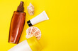 A suncream with shells are on the yellow background. Sun protection products are on the yellow background  
