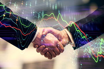 Double exposure of forex graph hologram and handshake of two men. Stock market concept.