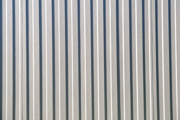 Gray corrugated metal fence on a sunny day..Corrugated surface seamless pattern.