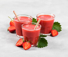 Strawberry smoothie in a jar with straws on a light background