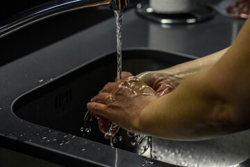 Poster - Shallow focus shot of a person washing hands in the sink