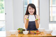 © Morakot - Beautiful Asian women, beautiful smile, good health, beautiful teeth, eating salad vegetable when working at home.