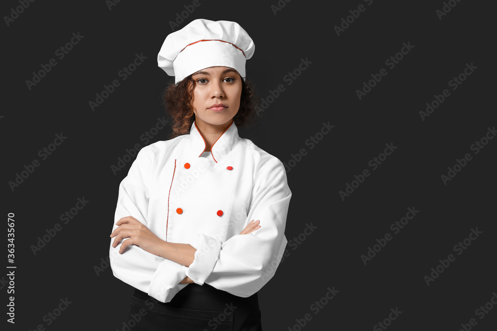 Female African-American chef on dark background