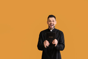 Wall Mural - Happy priest with Bible on color background