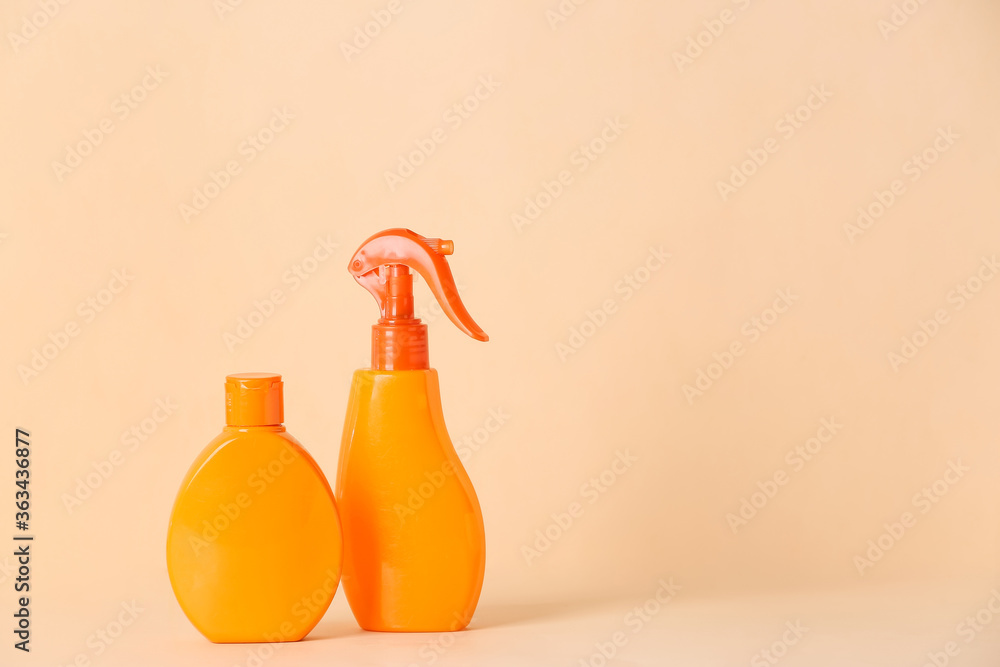 Bottles of sunscreen on color background